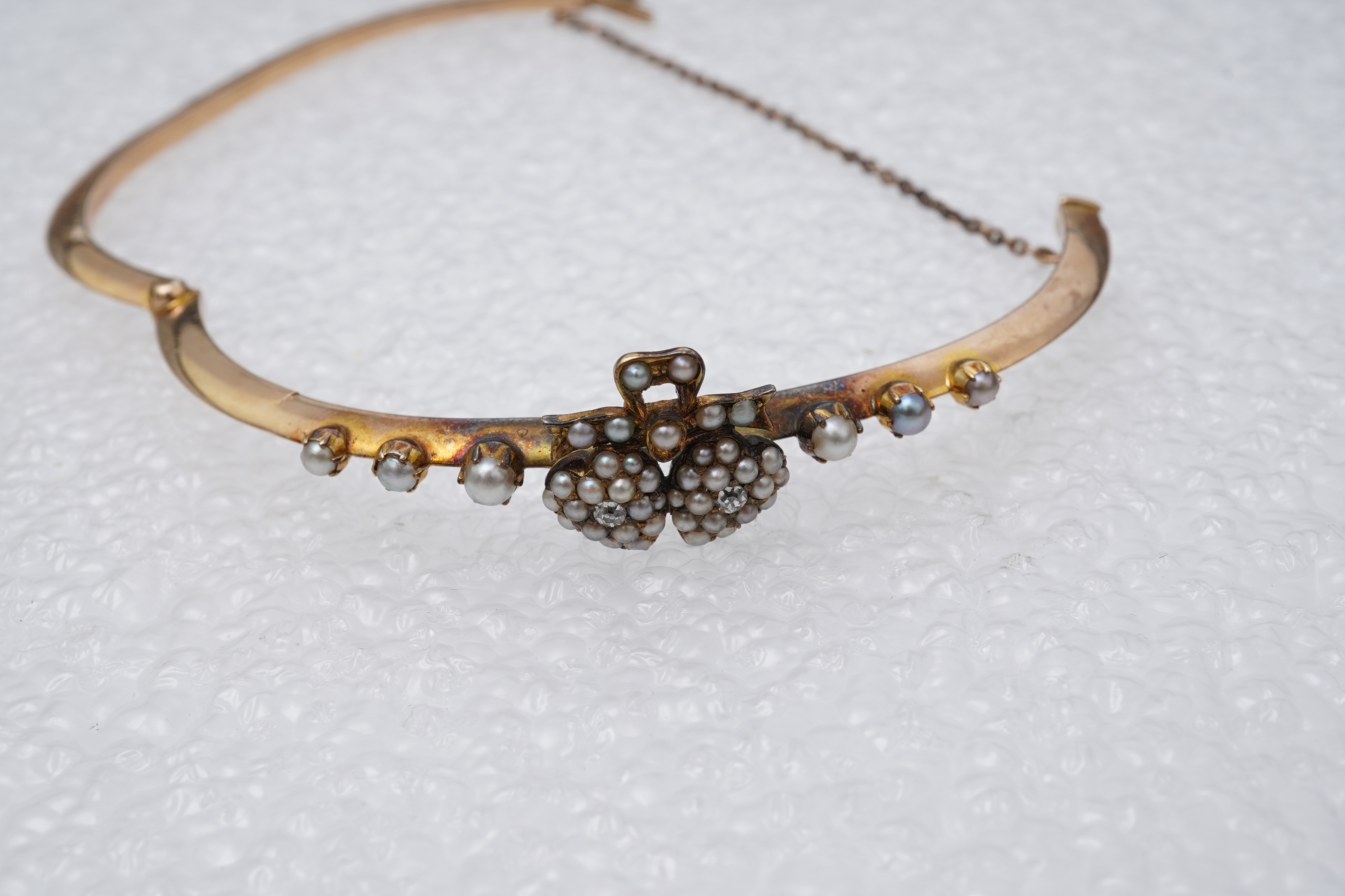 An Edwardian seed pearl and diamond bangle, early 20th century